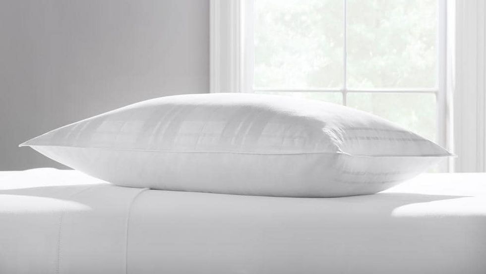 The Home Decorators Collection Down Surround Pillow is the best pillow for stomach sleepers in 2022. It lays on a bed.