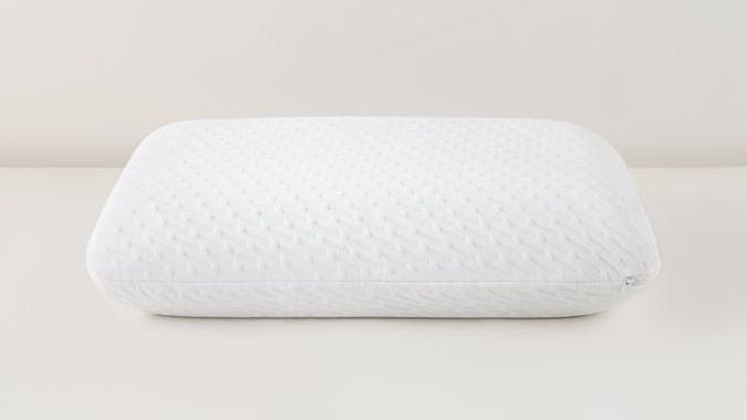 The Tuft & Needle Original Foam Pillow lays flat on the ground. It is a plump, round pillow and the best foam pillow in 2022.